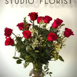 Red roses arranged in a clear glass vase