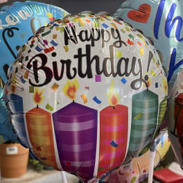 Birthday balloons with candles and confetti