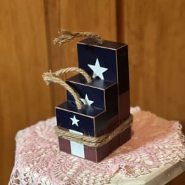 Stacked navy gift boxes tied with rope and star cutouts