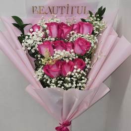 Bouquet of pink roses with baby's breath in pink wrapping