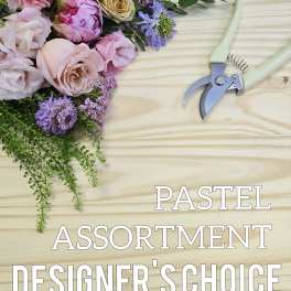 Pastel flower assortment with roses, peonies, and purple filler beside pruning shears