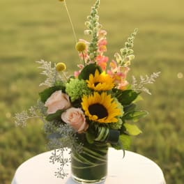 Sunflowers and pale pink roses in a glass vase