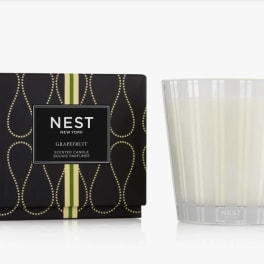 Scented candle in a frosted glass tumbler beside its black box