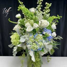 White roses and blue hydrangeas in a glass vase