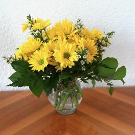 Yellow daisy bouquet in a clear glass vase