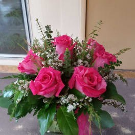 Bouquet of bright pink roses with small white filler flowers