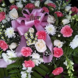 Pink and white floral wreath with a lavender ribbon reading Mom
