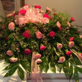 Large pink and red floral spray with ribbon accents