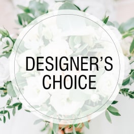 White floral arrangement with green foliage and a "Designer’s Choice" label