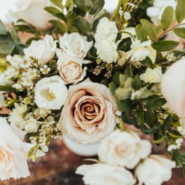 Arrangement of blush roses and white blooms in a soft neutral palette