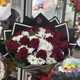 Bouquet of red roses and white daisies wrapped in black paper
