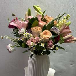 Mixed pink and peach bouquet in a white vase