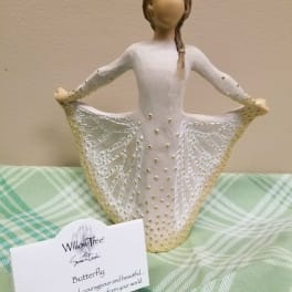 Decorative figurine of a girl in a white dress holding out her skirt