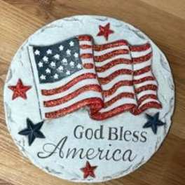 Round patriotic plaque with an American flag and the words God Bless America