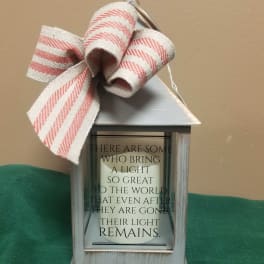 Decorative lantern with a striped bow and memorial quote