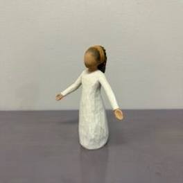 Small carved figurine of a person in a white dress