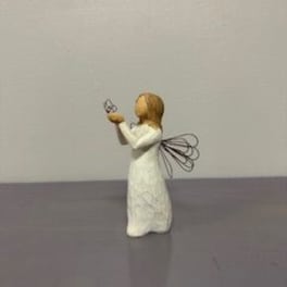 Small angel figurine in a white dress holding a butterfly