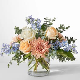 Bouquet of peach and white roses with a pink chrysanthemum in a glass vase