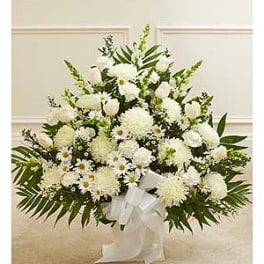 White floral standing spray with a white ribbon bow
