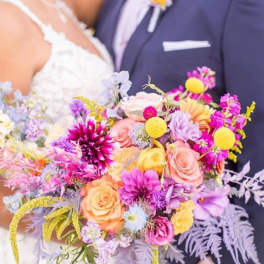 Bride and groom holding a colorful wedding bouquet
