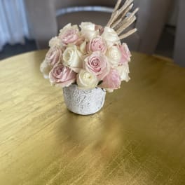 Pink and white rose bouquet in a small textured vase