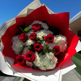 Bouquet of red roses and white hydrangeas wrapped in red and white paper