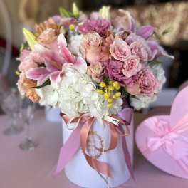 Pink and white bouquet in a white hatbox with ribbon