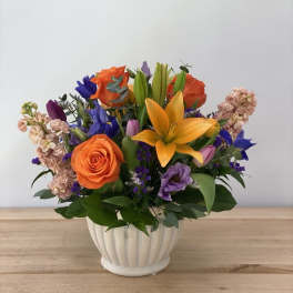 Colorful bouquet of roses and lilies in a white vase