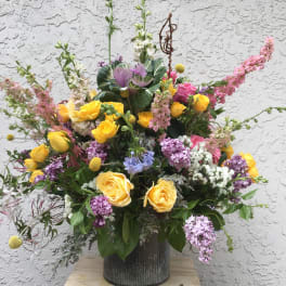Large mixed bouquet of yellow and pink roses in a metal vase