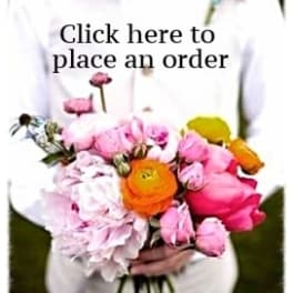 Person holding a bouquet of pink, orange, and yellow flowers