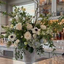 Large white floral arrangement in a gray pedestal vase