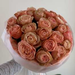 Bouquet of peach roses wrapped in pale pink paper