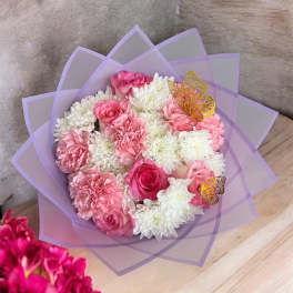 Pink and white bouquet wrapped in lavender paper