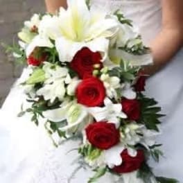 Bride holding a cascading bouquet of red roses and white lilies