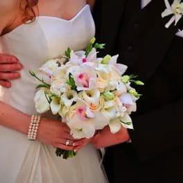 Bride and groom holding a white and blush wedding bouquet