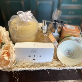 Gift basket with soap, lotion, tea, cups, and peach flowers
