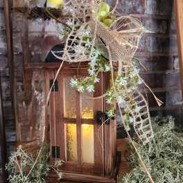 Wooden lantern with white flowers and a small bird decoration