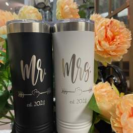 Two engraved tumblers with peach flowers around them