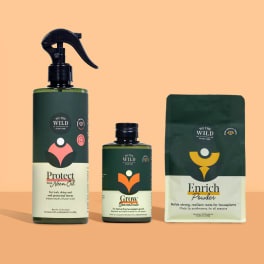 Three plant care products in dark green packaging on a peach background