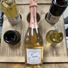 Five bottles of sparkling wine arranged in a wooden carrier