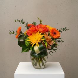 Orange and yellow mixed bouquet in a clear glass vase