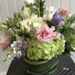 Mixed bouquet in a glass vase with pink, purple, white, and green blooms