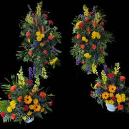 Four colorful floral arrangements with roses and daisies in white urns