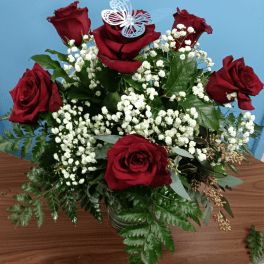 Red roses with white baby's breath in a glass vase