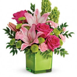 Pink lilies and roses in a green square vase