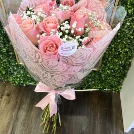 Pink rose bouquet with baby's breath in patterned wrap and ribbon