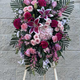 Standing floral spray with pink and white roses and lilies on an easel