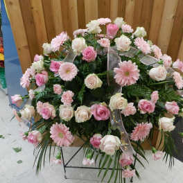 Large pink and white floral standing spray on a metal easel