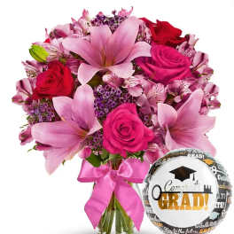 Pink and red bouquet with a graduation balloon and ribbon in a glass vase