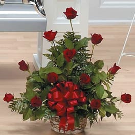 Basket arrangement of red roses with a large red bow
